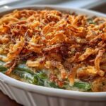 Close-up of a creamy green bean casserole topped generously with golden brown, crispy fried onions.