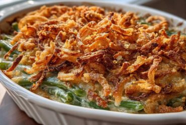 Close-up of a creamy green bean casserole topped generously with golden brown, crispy fried onions.