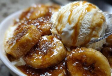 Close-up of caramelized bananas covered in sauce served with vanilla ice cream, a perfect serving of bananas foster.