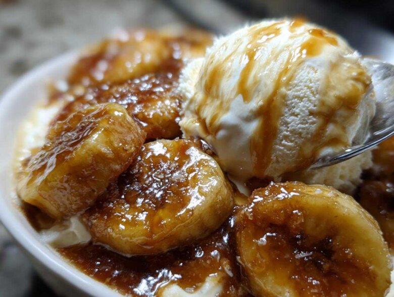 Close-up of caramelized bananas covered in sauce served with vanilla ice cream, a perfect serving of bananas foster.
