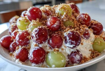 Close-up of creamy chicken salad chick grape salad topped with red and green grapes and brown sugar crumble.