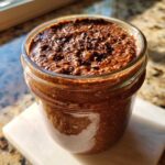 Close-up of rich, dark chocolate overnight oats topped with chocolate shavings in a glass jar.