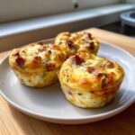 Three golden brown cottage cheese egg cups starbucks hack style served on a light plate.