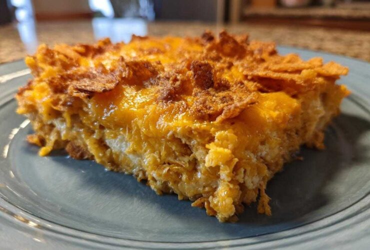 A close-up slice of baked Dorito Casserole showing melted cheese and crunchy topping.
