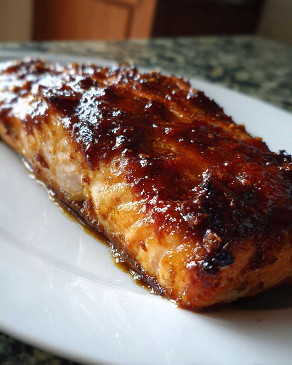 Close-up of a perfectly baked salmon fillet with a dark, shiny, caramelized glaze.