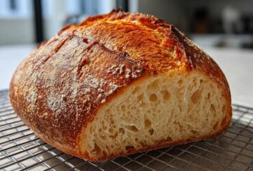 Close-up of a rustic Italian bread loaf, sliced to show the airy crumb and deep golden crust.