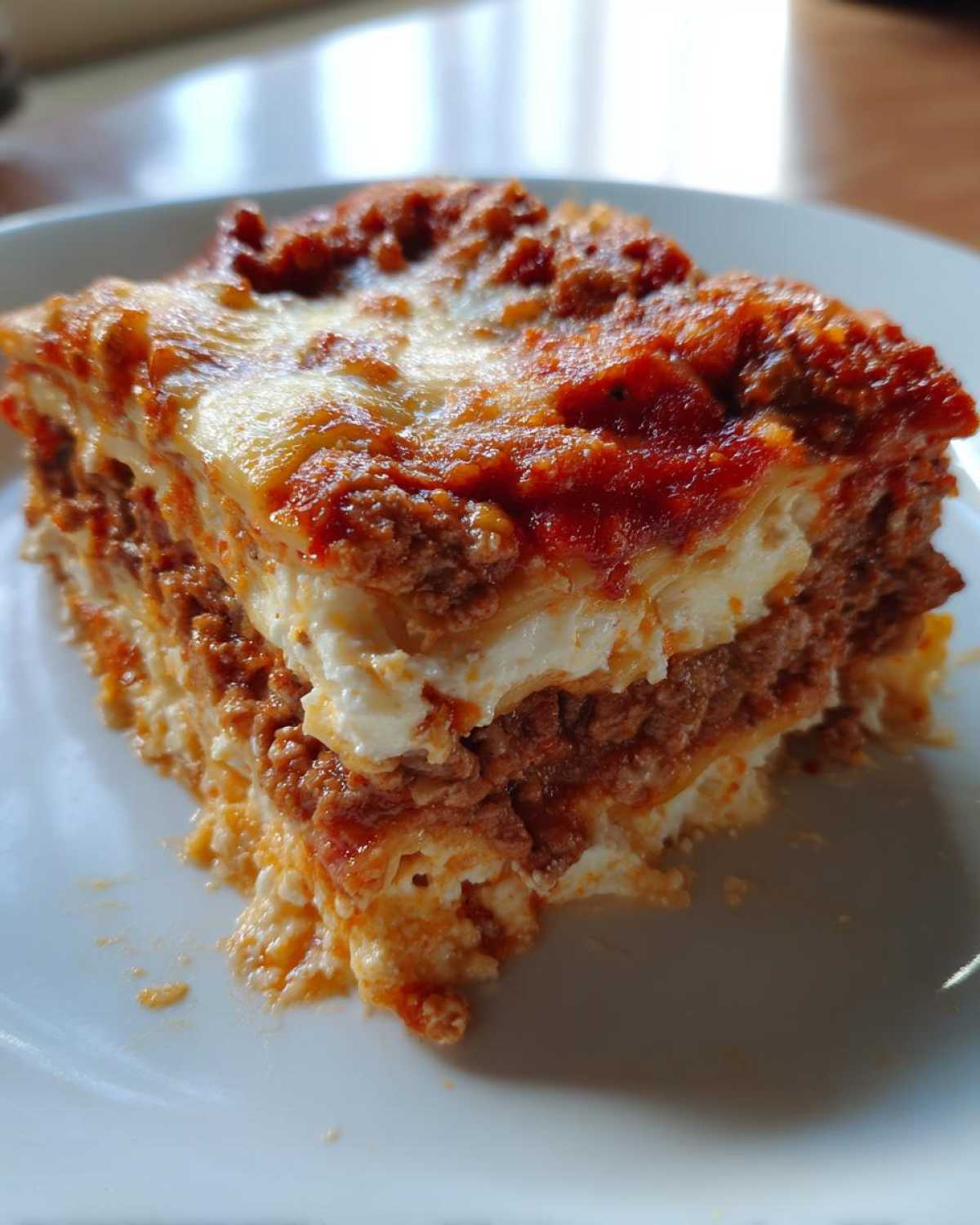 A close-up slice of layered Lasagna with Cottage Cheese, featuring rich meat sauce and creamy white layers.