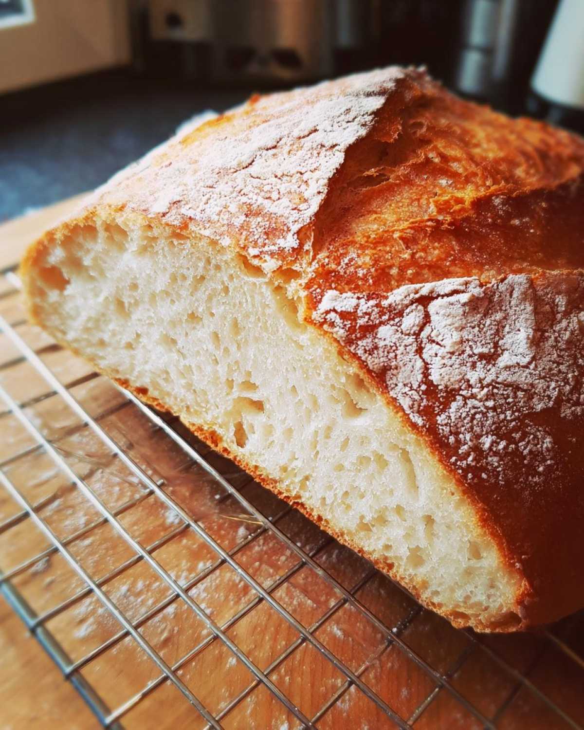 Close-up of a freshly baked French bread loaf cut in half, showing the soft white crumb and golden crust.