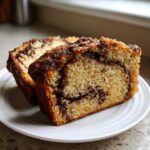 Two moist slices of sour cream coffee cake featuring a rich cinnamon swirl and crunchy streusel topping.