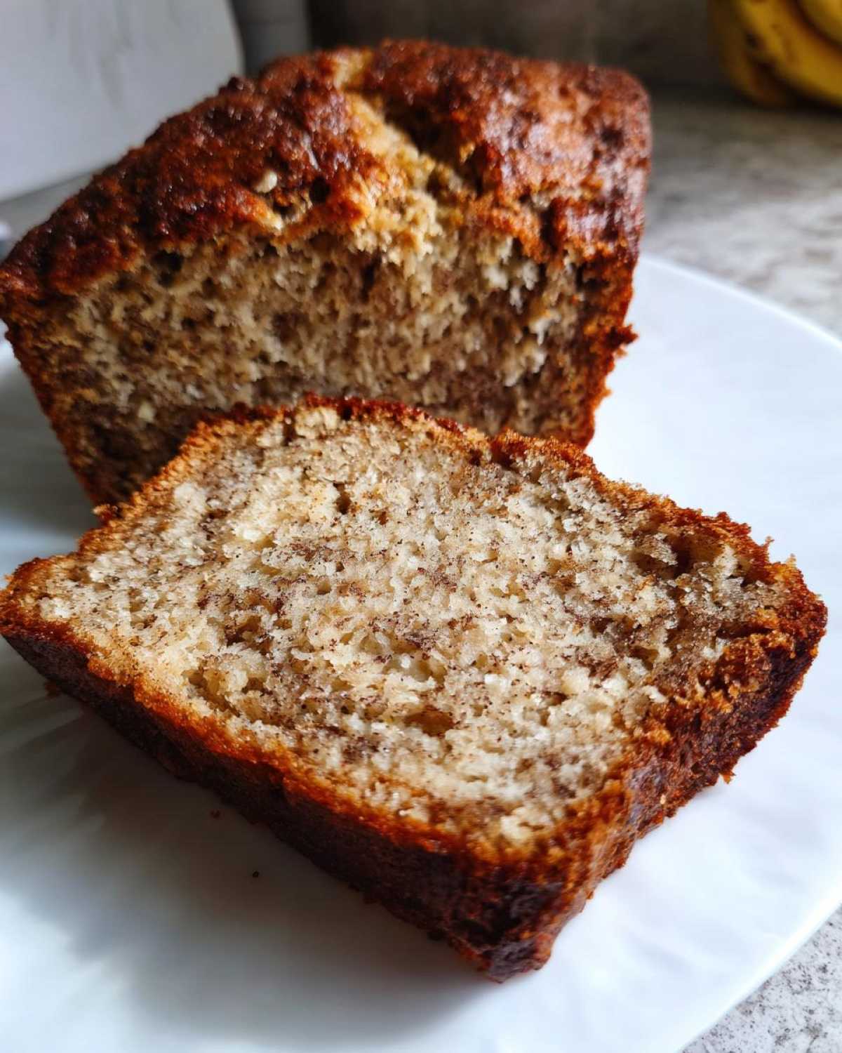 Close-up of a slice of moist sugar free banana bread showing its crumb texture and browned crust.