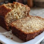 Close-up of a moist slice cut from a loaf of sugar free banana bread, showing its crumb texture.