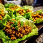 Close-up of delicious chicken lettuce wraps filled with savory ground chicken and topped with fresh green onions.