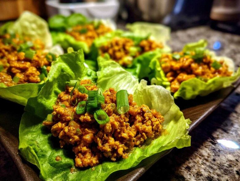 Close-up of delicious chicken lettuce wraps filled with savory ground chicken and topped with fresh green onions.