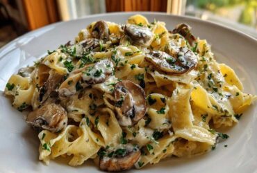 Close-up of creamy mushroom pasta featuring wide noodles, sliced mushrooms, and chopped parsley.