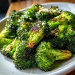 Close-up of vibrant green roasted broccoli florets sprinkled with Parmesan cheese.