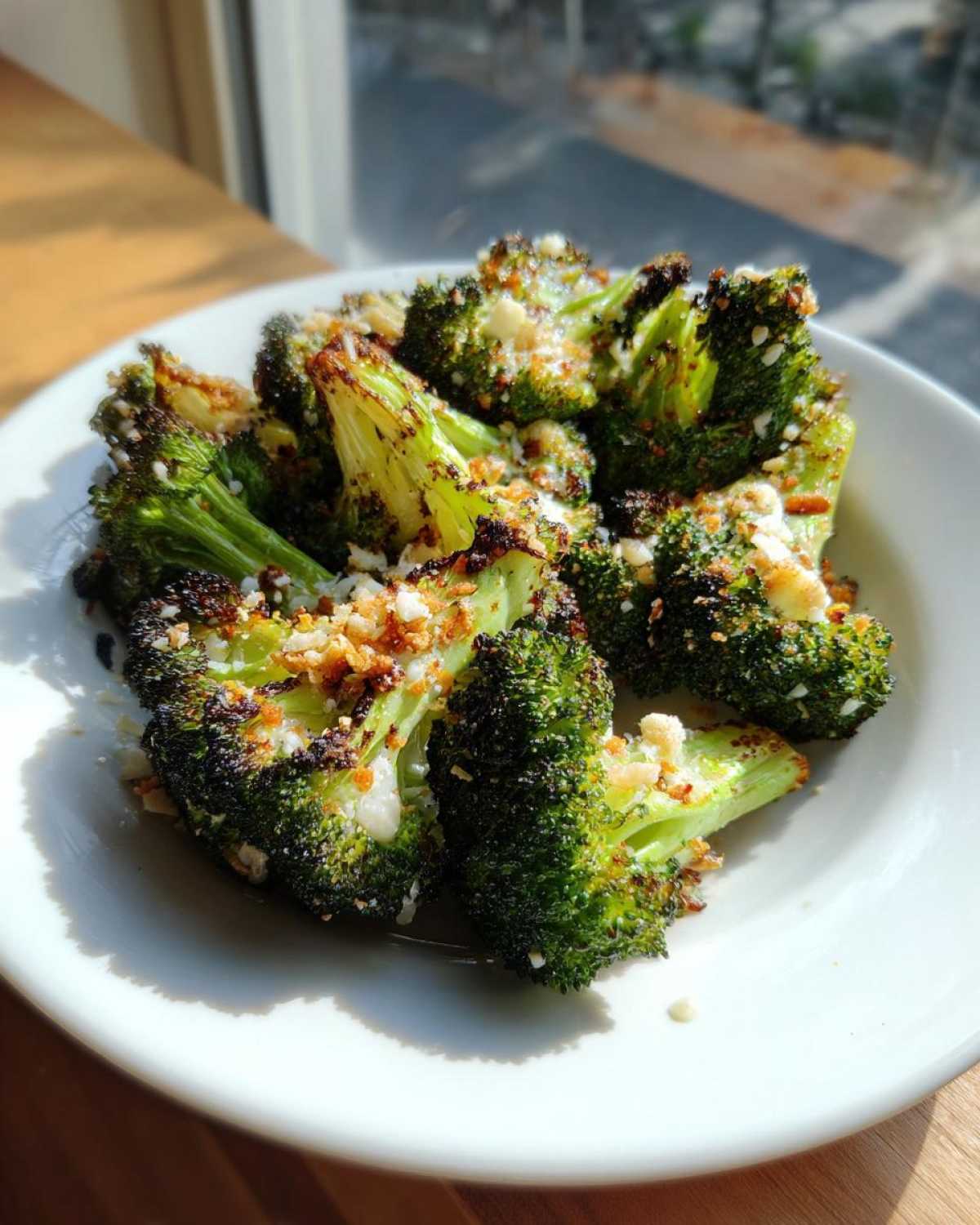 Close-up of perfectly roasted broccoli florets topped with crispy breadcrumbs and cheese.