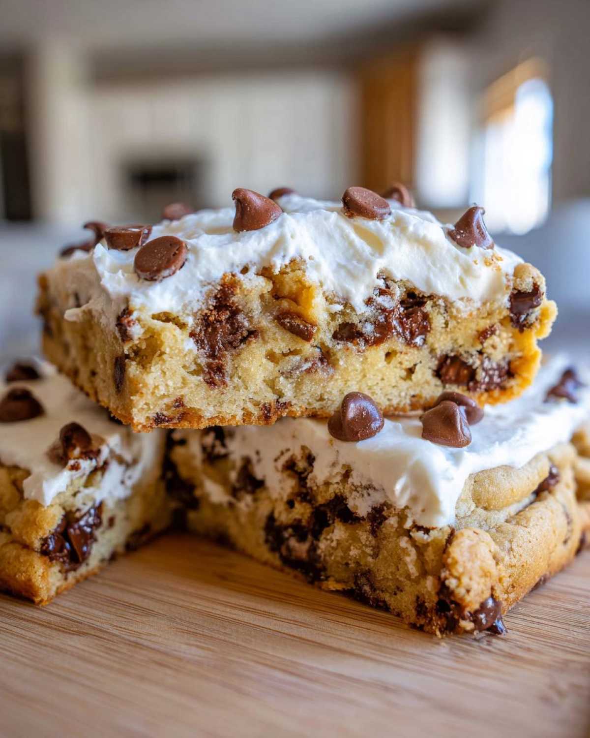 Two stacked slices of chewy cookie cake recipe topped with thick white frosting and chocolate chips.