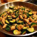 Close-up of juicy chicken pieces and bright green zucchini slices in a savory sauce, part of the chicken zucchini stir fry.