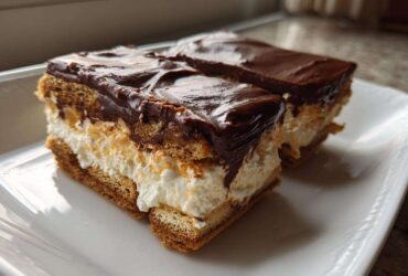 Two rectangular slices of amazing 3 layer chocolate eclair cake with creamy filling and rich chocolate topping.