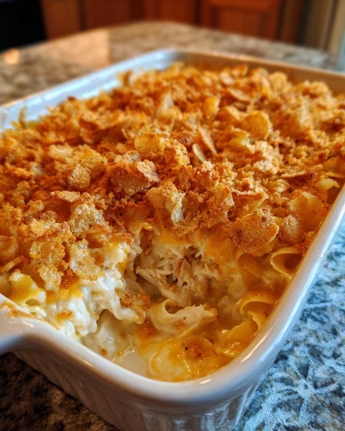 Close-up of a creamy chicken noodle casserole with egg noodles, shredded chicken, and a golden, crunchy topping.