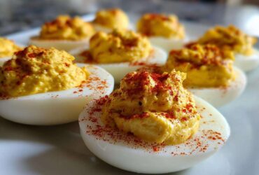 Close-up of creamy deviled egg filling topped with paprika, illustrating perfect egg preparation.