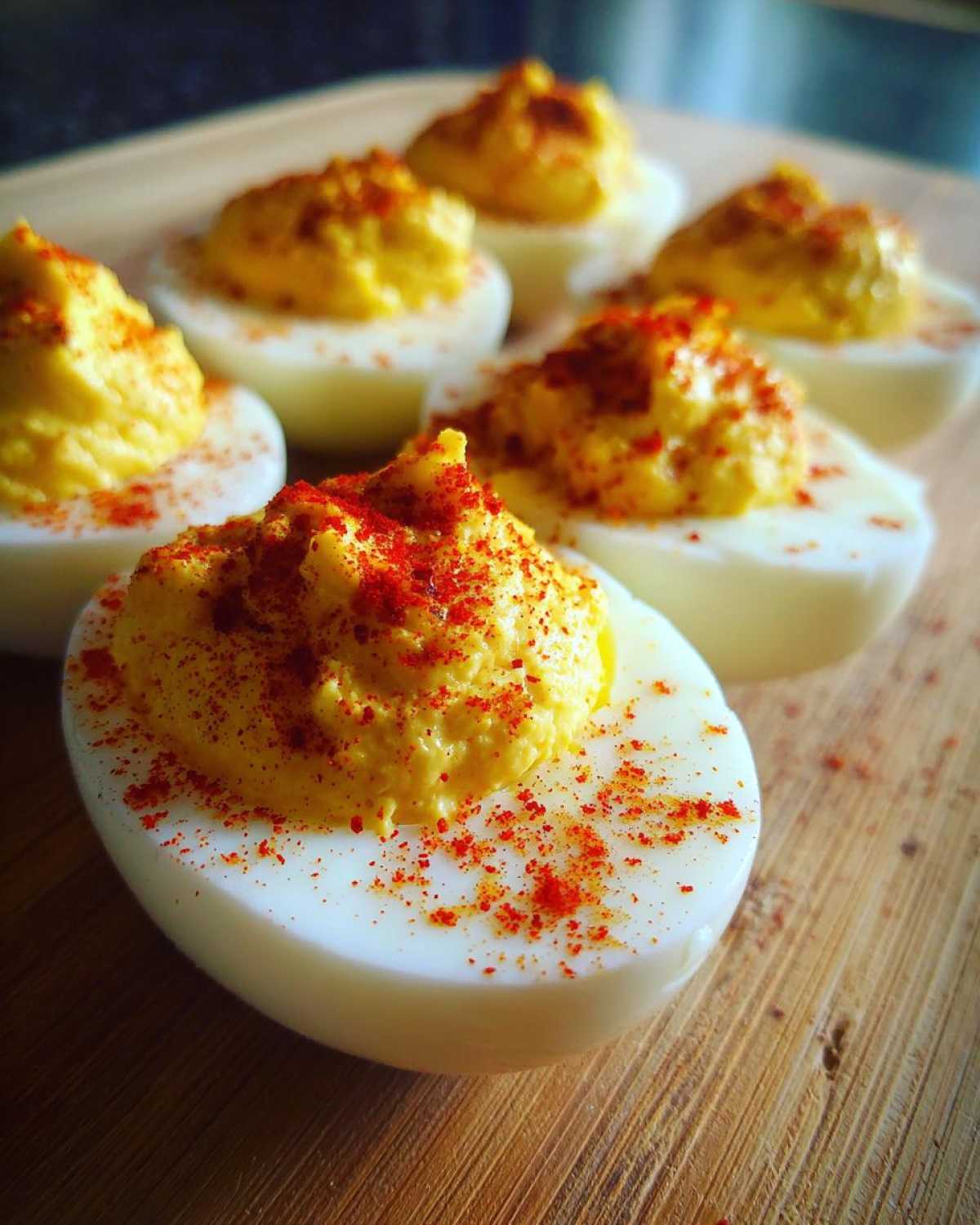 Close-up of creamy deviled egg halves dusted with paprika, showcasing the perfect egg filling.
