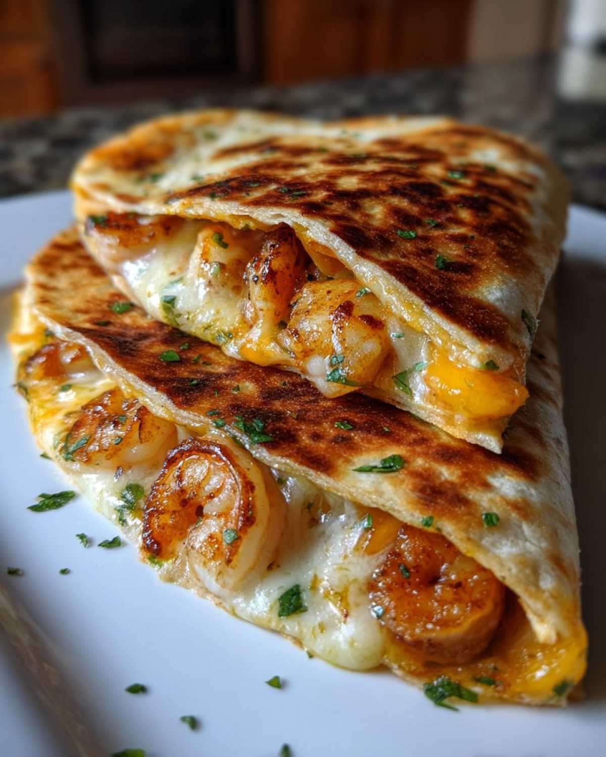 Close-up of two halves of a golden-brown shrimp quesadilla oozing melted cheese and seasoned shrimp.