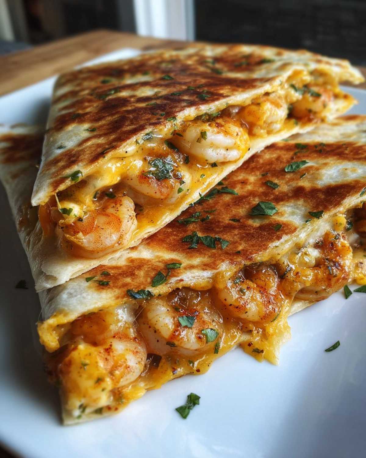 Close-up of a perfectly grilled shrimp quesadilla slice, showing melted cheese and seasoned shrimp filling.