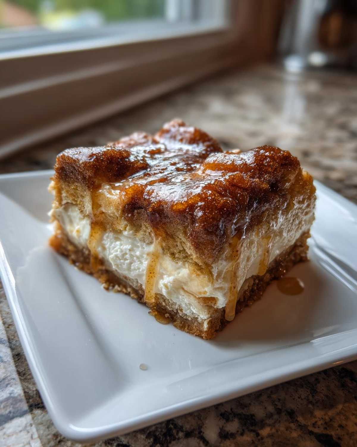 Close-up of a single serving of sopapilla cheesecake bars, showing the creamy filling and cinnamon-sugar topping with glaze.