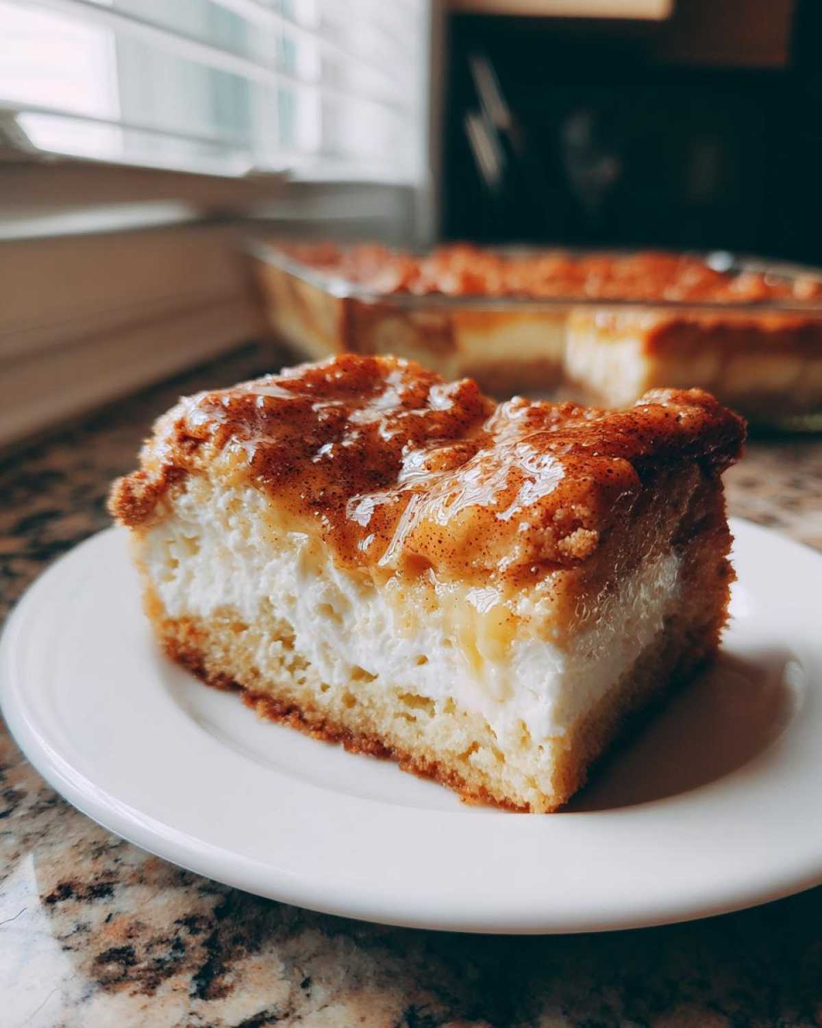 A close-up view of a thick slice of sopapilla cheesecake bar with creamy filling and cinnamon sugar topping.
