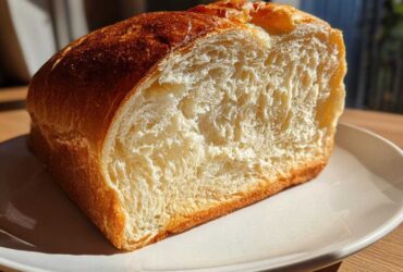 Close-up of the soft, fluffy interior crumb of a freshly baked sourdough sandwich bread loaf.