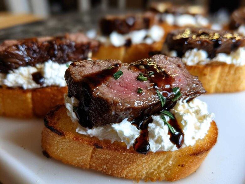 Close-up of a perfectly cooked steak crostini topped with creamy cheese and drizzled with balsamic glaze.