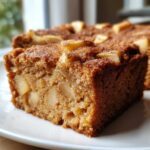 Close-up of a moist slice of apple cinnamon cake moist, easy, showing chunks of apple and cinnamon sugar topping.