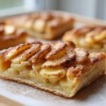 Close-up of a single serving of the best apple puff pastry, topped with sliced apples and cinnamon.