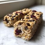 Close-up of chewy no bake granola bars packed with oats, chocolate chips, and dried cranberries.
