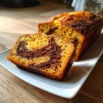 Close-up of a slice cut from a cinnamon swirl pumpkin bread mini loaf showing the marbled interior.