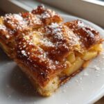 Close-up of two golden brown slices of classic apple puff pastry theamazingfood topped with coarse sugar.