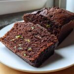 Close-up of a sliced Classic Chocolate Zucchini Loaf Cake showing the moist, dark crumb and flecks of green zucchini.