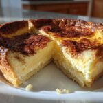A cross-section view of a creamy apple custard impossible pie with a golden-brown, slightly burnt top.
