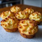 Close-up of several golden brown, piped Duchess potatoes baked in muffin tins.