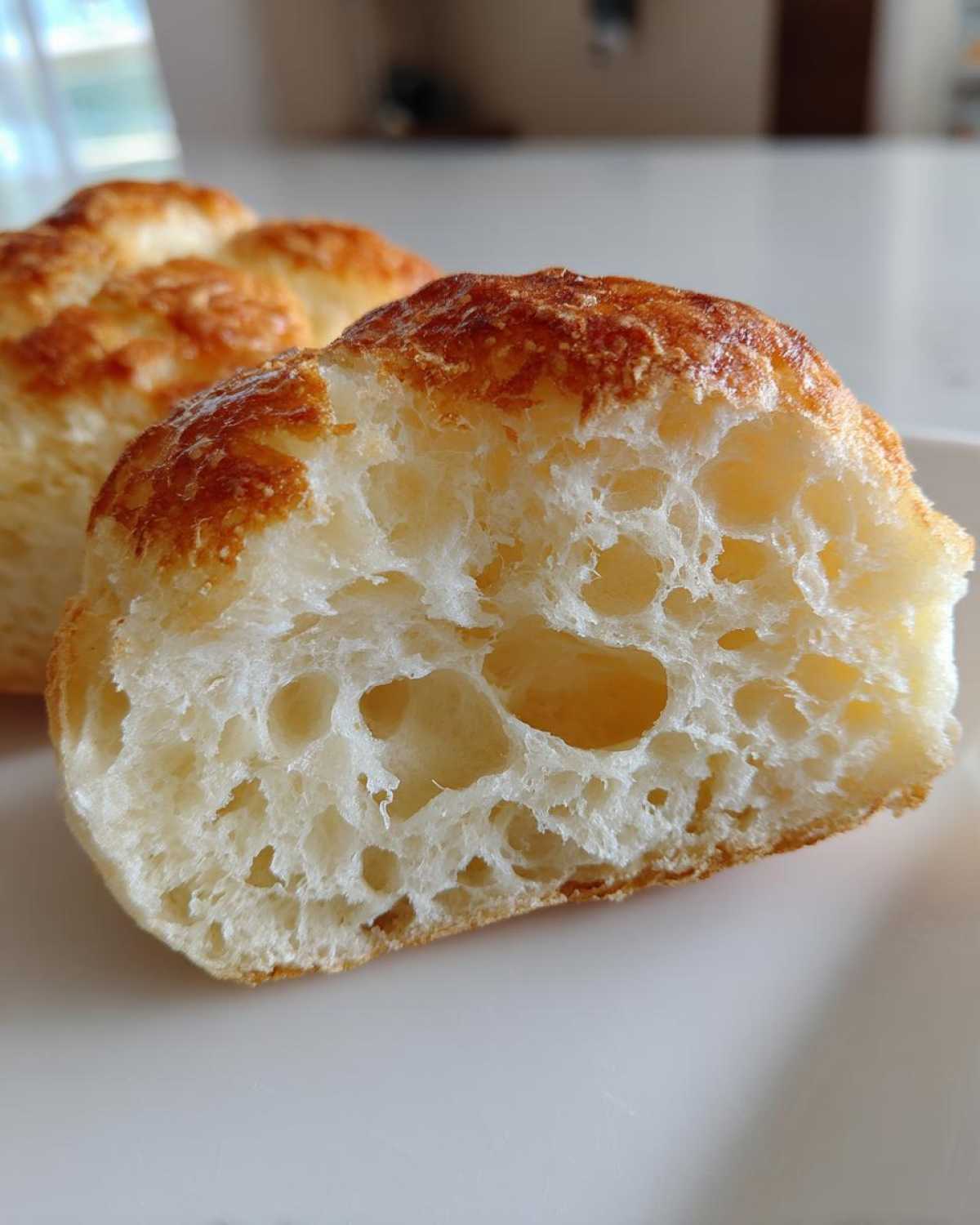 Close-up of a split english muffin revealing its airy interior texture with many nooks and crannies.