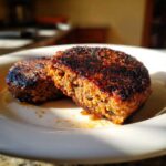 Close-up of a perfectly seared, firm black bean burger patty cut in half showing the texture inside.