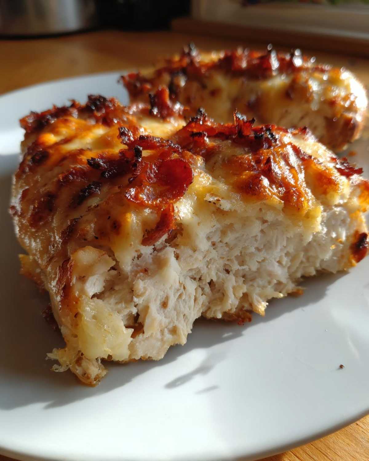Close-up of a juicy, cross-section of french onion chicken topped with melted cheese and caramelized onions.