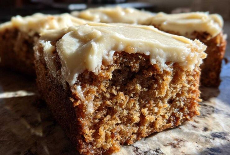 Close-up view showing the moist, spiced interior and thick cream cheese frosting of Frosted Zucchini Spice Bars.