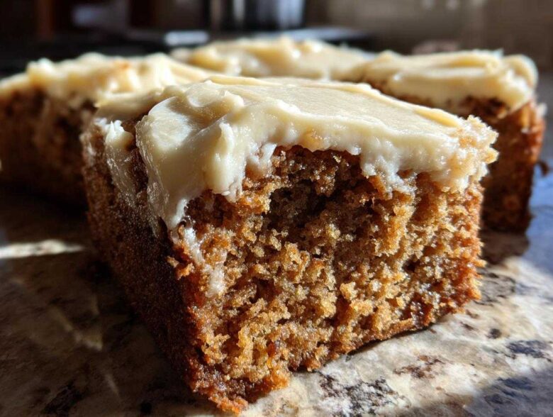 Close-up view showing the moist, spiced interior and thick cream cheese frosting of Frosted Zucchini Spice Bars.