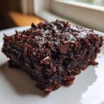 Close-up of a rich, fudgy square of Gluten Free Zucchini Brownies topped with chocolate chips.