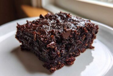 Close-up of a rich, fudgy square of Gluten Free Zucchini Brownies topped with chocolate chips.