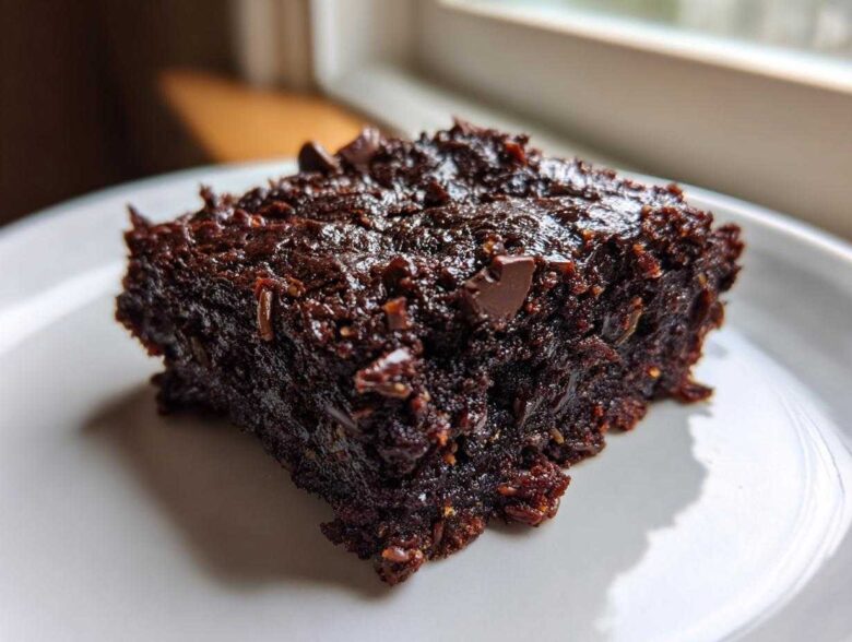 Close-up of a rich, fudgy square of Gluten Free Zucchini Brownies topped with chocolate chips.