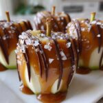 Four gourmet Caramel Apple Slices covered in thick caramel, drizzled with dark chocolate, and sprinkled with sea salt.
