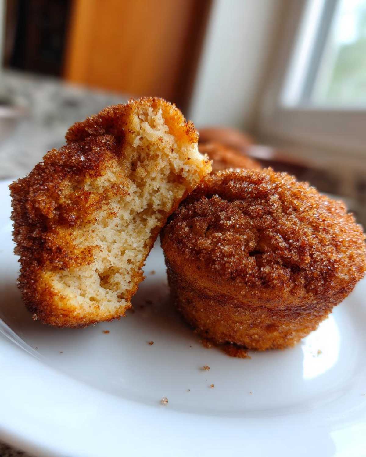 Close-up of one Mini Apple Cider Donut Muffin cut in half showing the soft interior and cinnamon sugar coating.